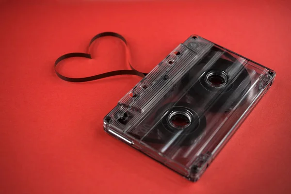 ヴィンテージ古い映画音楽カセットで流行のピンク赤の背景にフィルムハート形 背景音楽 音楽愛好家 — ストック写真