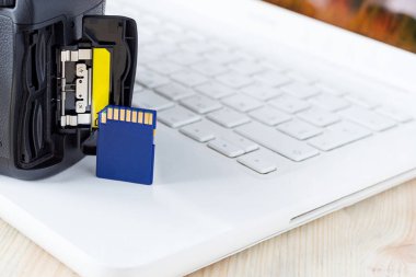 Kamera ve dizüstü bilgisayarın arkaplanındaki flaş kart, Slr kamera hafıza kartı, flash disk, fotoğraf depolama, fotoğrafçının iş yeri