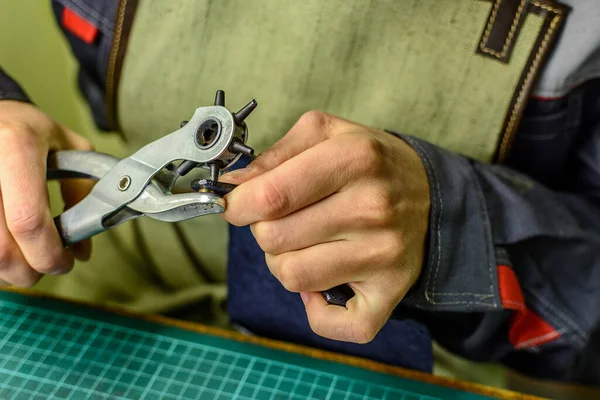 Tabakhanede çalışıyorum. Perçini ürüne takıyorum.