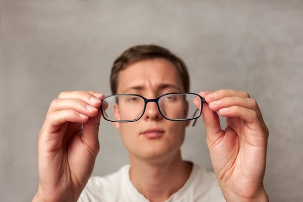 Νεαρός Άνδρας Κρατά Γυαλιά Φακούς Διόπτερου Και Κοιτάζει Μέσα Από — Φωτογραφία Αρχείου