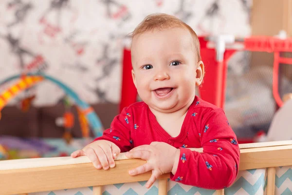 小さな子供が立ってベッドの端を保持したり 保育園で遊んだり 幸せで幸せな笑顔の赤ちゃん 子供の発達の概念 最初のステップ — ストック写真