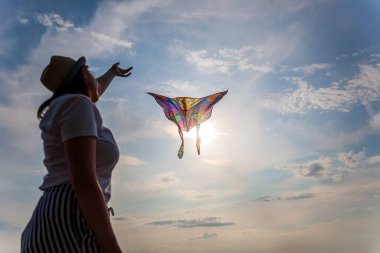 Yazın mavi gökyüzüne karşı uçurtma uçurmak, uçurtma fırlatmak, eğlenceli yaz tatili, özgürlük kavramı