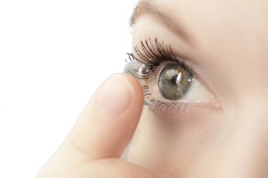 Yumuşak kontakt lens takan kız beyaz arka grupta izole edilmiş makro kamera.