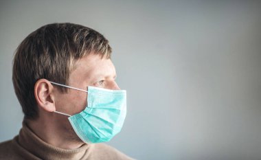 Tıbbi maskeli bir adam.