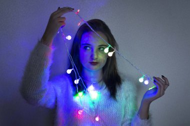 Beyaz arka planda Noel çelengi olan genç bir kız