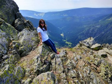 Genç neşeli yürüyüşçü kız koyu saçlı yüksek dağlarda yaz mevsiminde.