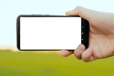 Günbatımı arka planında beyaz ekranlı modern telefon