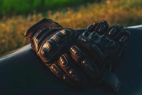 black motorcycle gloves for safety lie on a black surface close up