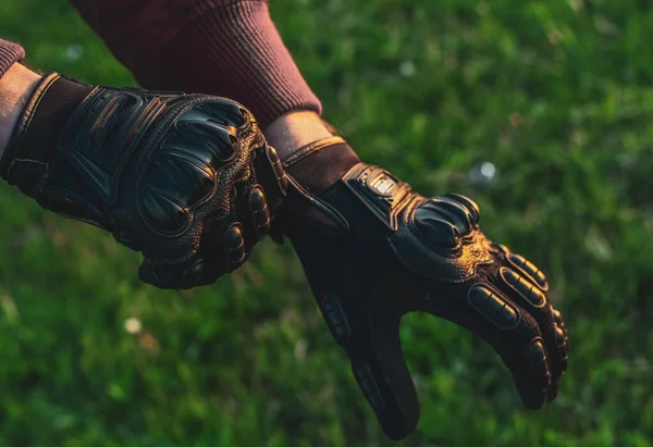 black motorcycle gloves guy puts on his hands for safety close up