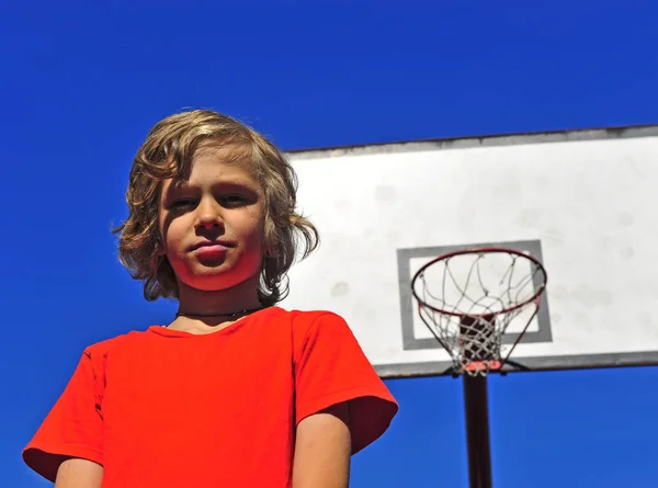 Happy smiling boy with basketball hoop on background — Stock Photo, Image