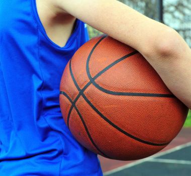 Mavi topla üniforma giyen basketbolcu