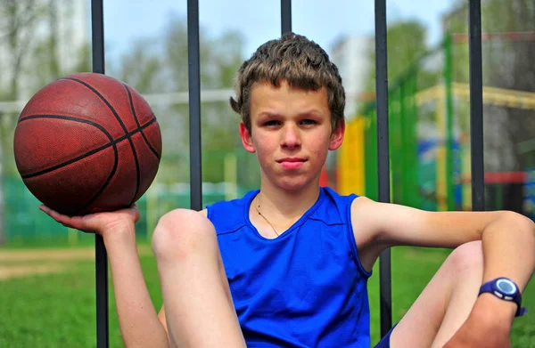 Enfant avec un ballon de basket au terrain de sport — Photo