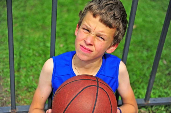 Malý basketbalový hráč, sedící na kurtu — Stock fotografie