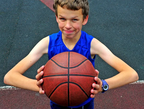 Jeune joueur avec un ballon de basket sur le terrain — Photo