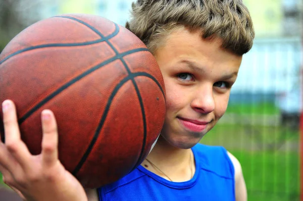 Підліток з баскетболом на дворі — стокове фото