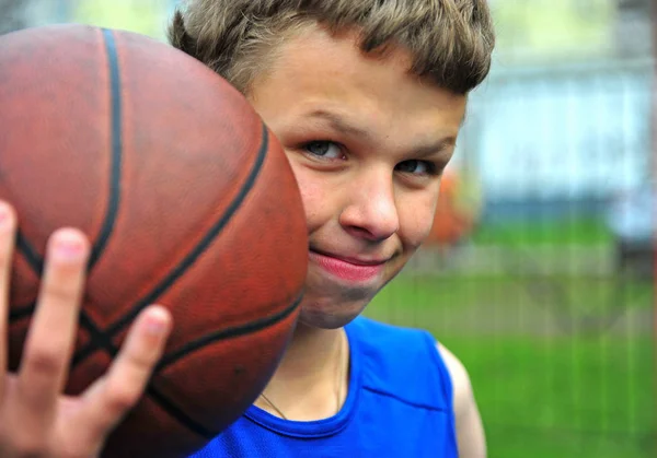 Retrato de um adolescente com uma bola de basquete — Fotografia de Stock