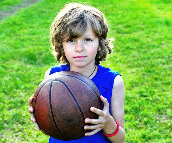 Portrait d'un enfant avec un ballon de basket sur herbe — Photo