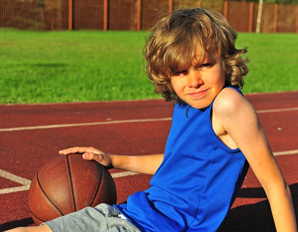 Shaggy pojke på domstolen med basket — Stockfoto