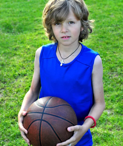 Jongen in blauw shirt met een basketbal — Stockfoto