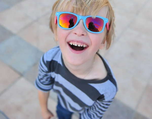 Portræt af en glad dreng iført solbriller - Stock-foto