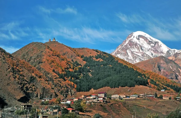 Kazbegi dorp en Trinity Kerk in Bergen — Stockfoto