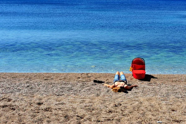 Plajda yatan bir yenidoğan ile anne — Stok fotoğraf