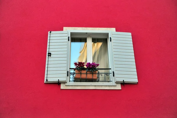 Mooie houten venster in de diepe rode muur — Stockfoto