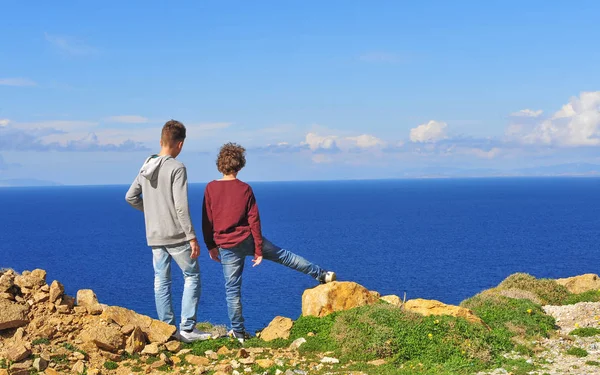 Due ragazzi in piedi sulle scogliere vicino al mare — Foto Stock