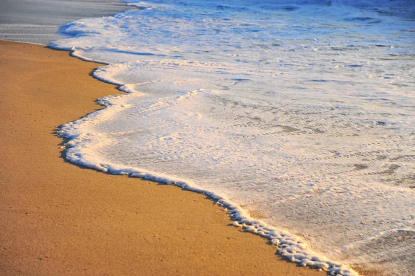 Meereswellen und goldener Sand am Strand — Stockfoto