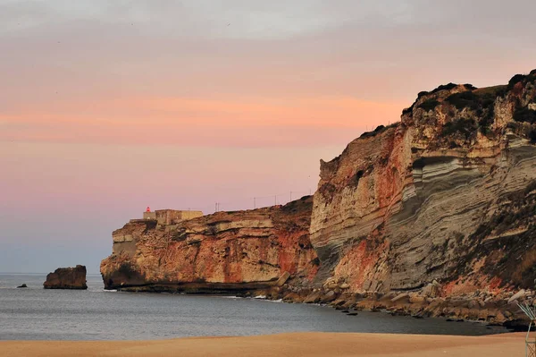 Belo farol de Nazare resort ao pôr-do-sol — Fotografia de Stock