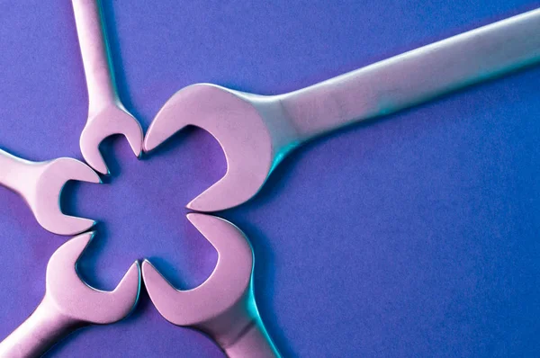 Somun anahtarları ile bir yıldız şekli. Mavi arka planda ultraviyole araçlarda. Takım ruhu konulu Tasarla.