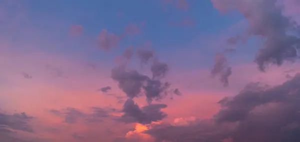 Arka planını mor ve mavi tonlar, bulutlu gökyüzü günbatımı.