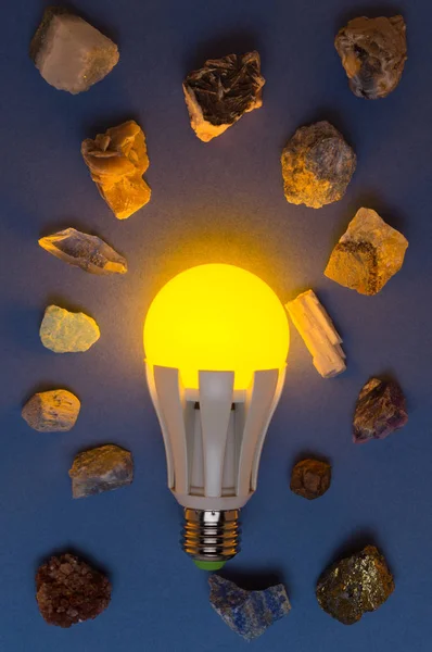 Sarı lamba ve birçok farklı mineral mavi bir arka plan üzerinde yol açtı. Earth Hour enerji tasarrufu yapın ve doğal kaynakları korumak için fikir.