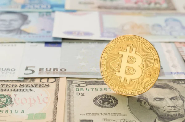 Farklı banknot arka plan üzerine bir bitcoin.