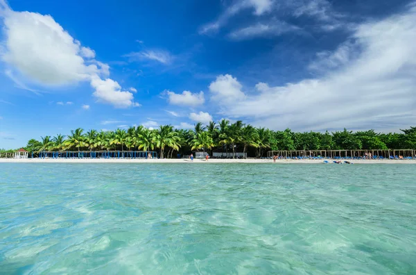 Úžasný bílý písek zvoucí palm beach s nadýchanými mraky, pohled ze strany oceánu — Stock fotografie