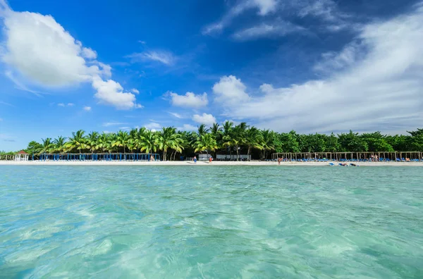 Amazing white sand inviting palm beach with fluffy clouds, view from the ocean side — Stock Photo, Image