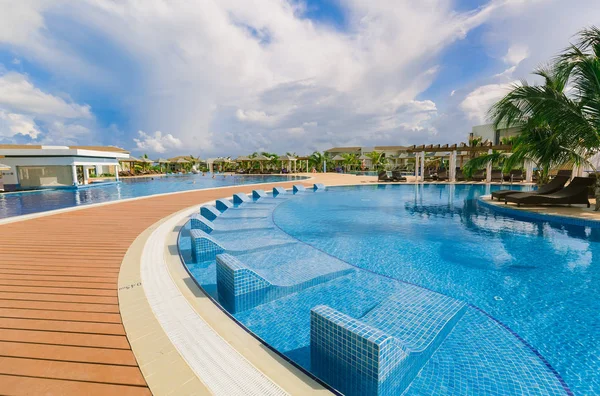 Hermosa vista atractiva de una piscina cómoda curvada con camas de piscina de cerámica —  Fotos de Stock
