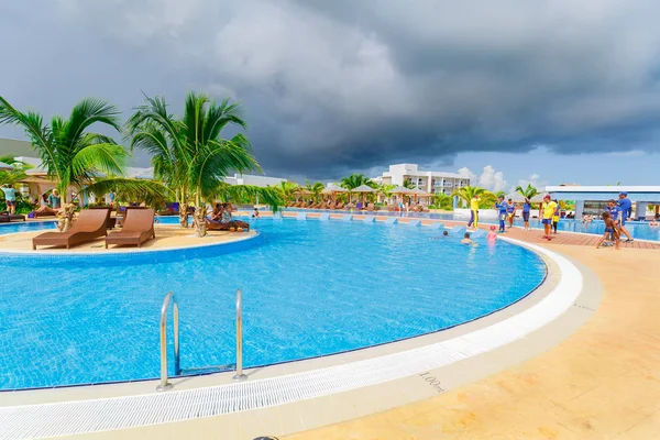 Vista de una piscina curvada amplia y cómoda con equipo de entretenimiento y personas disfrutando de su tiempo — Foto de Stock