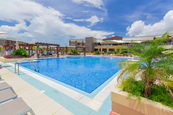 Acogedora vista del complejo piscina al aire libre y jardines del hotel con personas que se relajan en el fondo — Foto de Stock