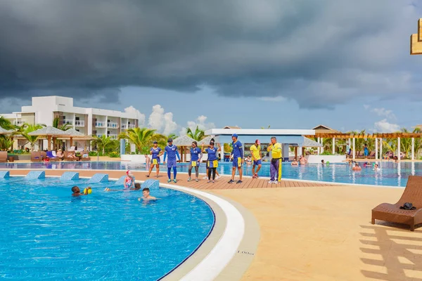 Cómoda y acogedora piscina con equipo de animación y nadadores de fondo Fotos de stock