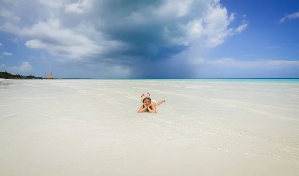 Sonrisa feliz niña acostada en el agua clara del océano y relajarse en la isla de Cayo Coco playa increíble — Foto de Stock