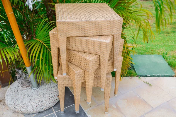 Nice closeup view of patio woven chairs or tables stacked in tropical garden — Stock Photo, Image