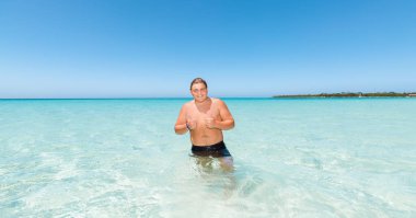  yakışıklı mutlu gülümseyen genç çocuk okyanusta güneşli güzel günde duran güzel manzara