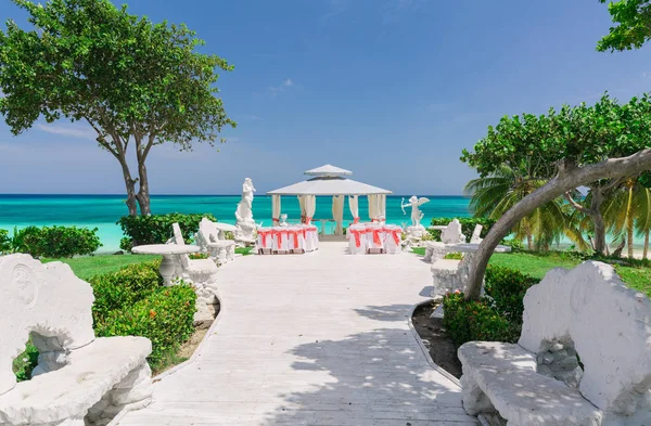 Hermosa vista del evento de ceremonia de boda decorado cenador contra el cielo azul y el fondo del océano en el jardín tropical — Foto de Stock