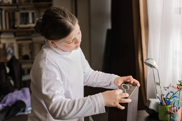 Kleines Mädchen fand ihren staubigen alten Koffer und versuchte ihn zu öffnen — Stockfoto