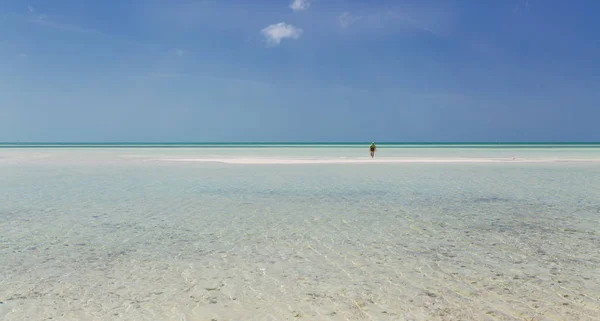 Great view of  Cuban Cayo Coco island wild beach with turquoise, tranquil ocean and person going far toward horizon line on sunny gorgeous day — Stock Photo, Image