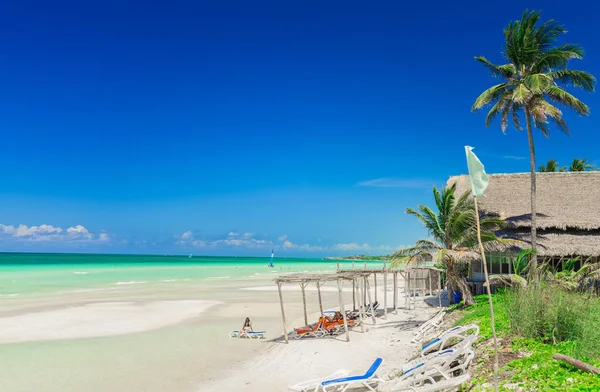 Schöne einladende Aussicht auf tropischen Strand und türkisfarbene Ruhe mit Menschen, die sich entspannen und ihre Zeit an sonnigen schönen Tag genießen — Stockfoto