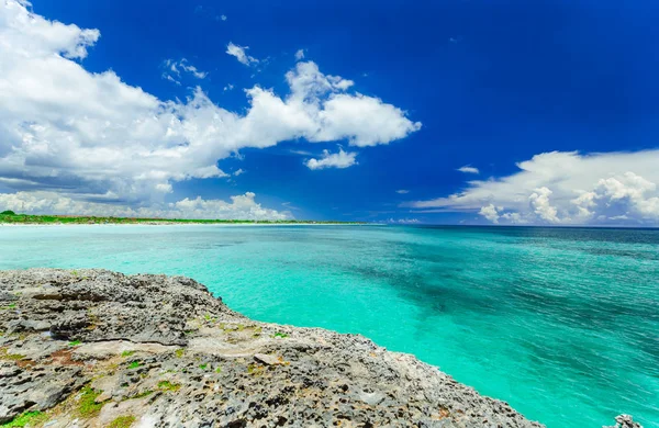 Hipnotizante excelente vista de um penhasco no tranquilo oceano azul-turquesa contra o céu azul fundo mágico — Fotografia de Stock