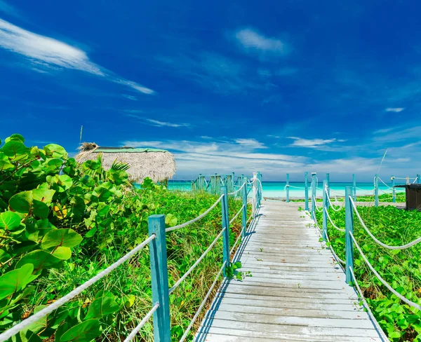 Piękny widok z drewniany most, prowadzący do piaszczystej plaży i spokojny turkus oceanu — Zdjęcie stockowe