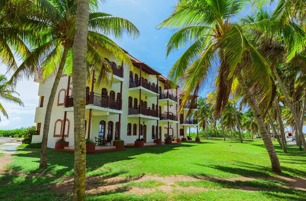 Vue imprenable sur le terrain de l'hôtel colonial, de beaux bâtiments élégants rétro accueillants dans un jardin tropical sur ciel bleu — Photo